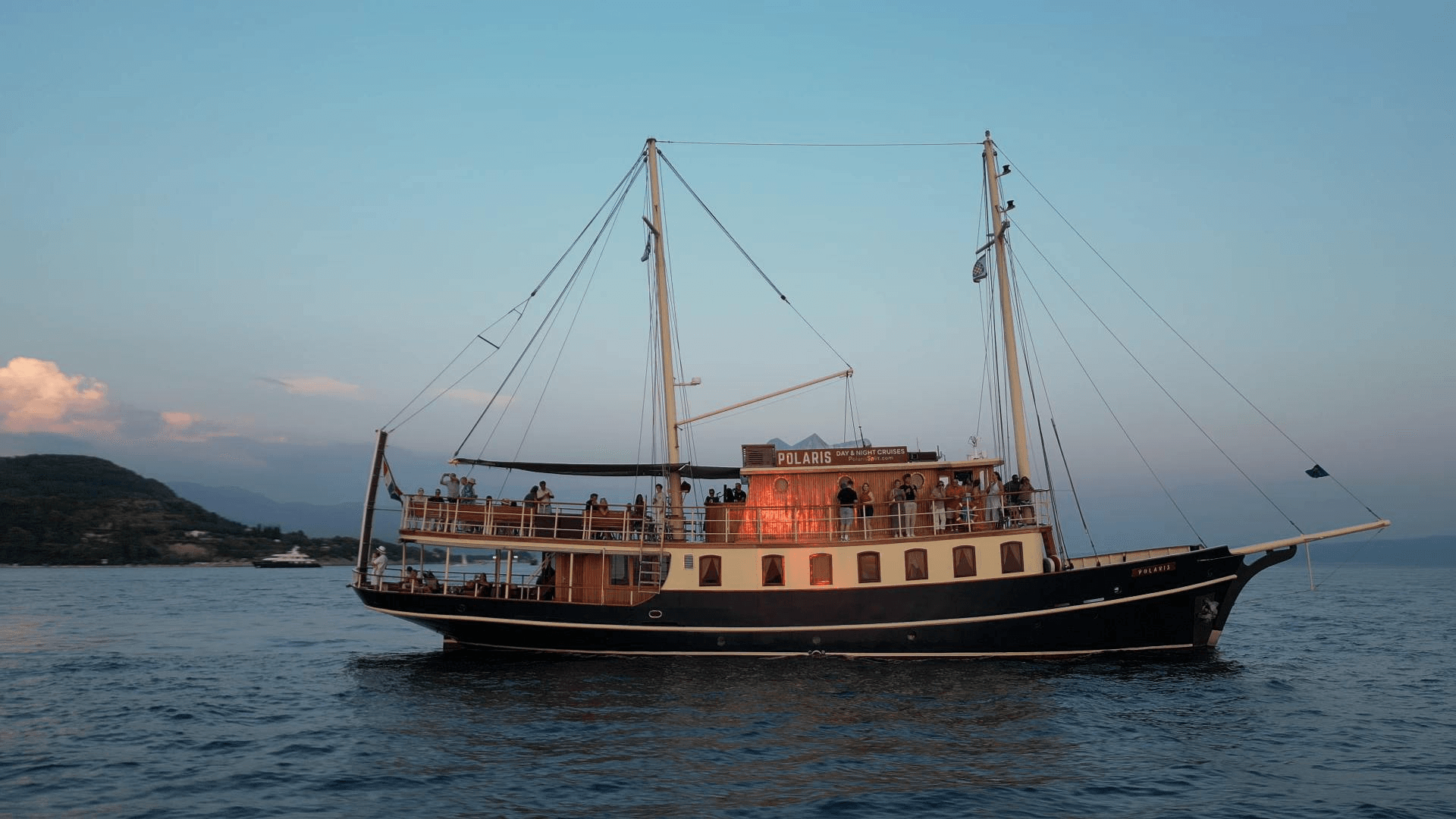 Jahta Polaris u sumrak s gostima na palubi ispod svijetlećeg natpisa Day & Night Cruises
