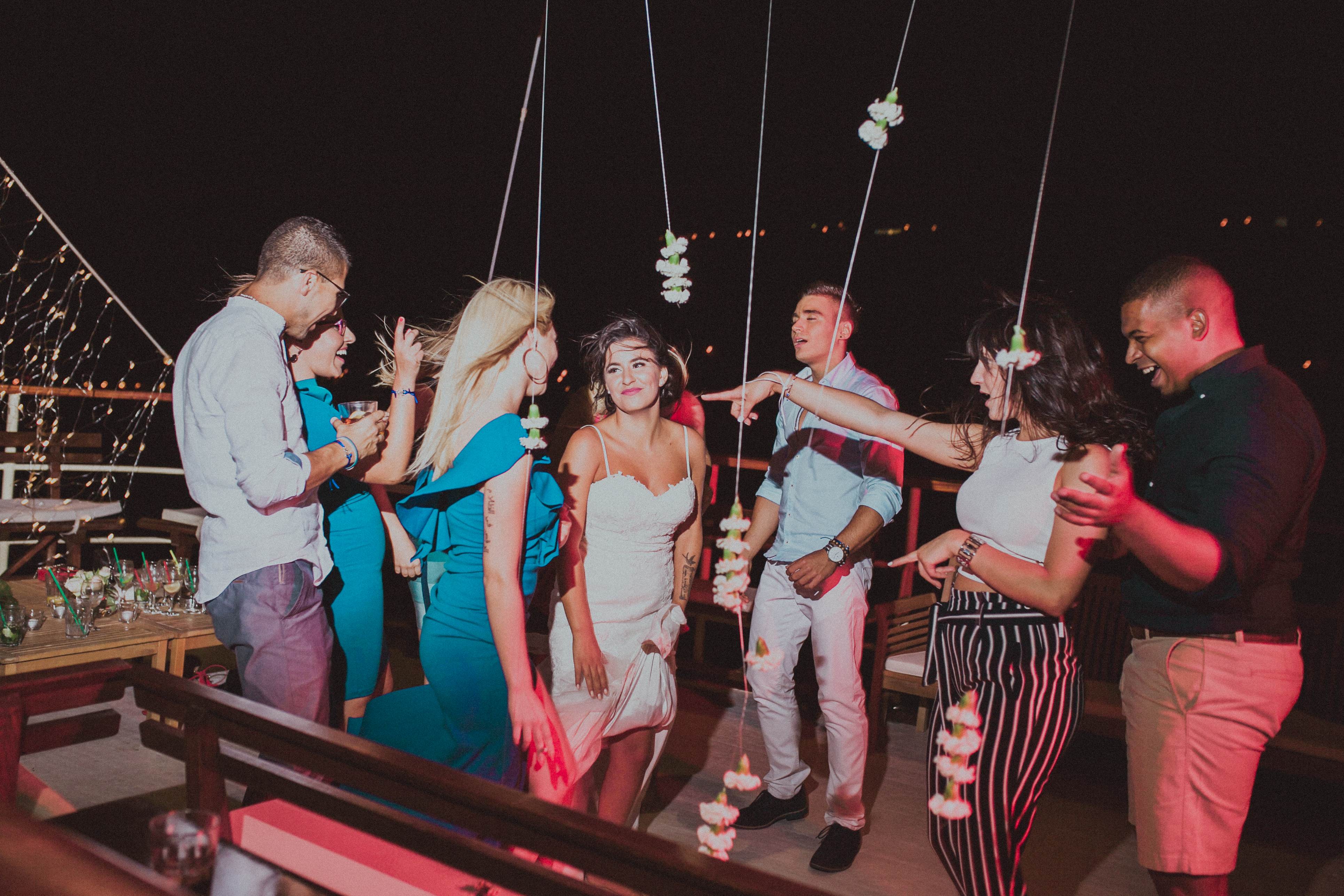 Guests laughing and dancing at an evening party on the deck of Polaris