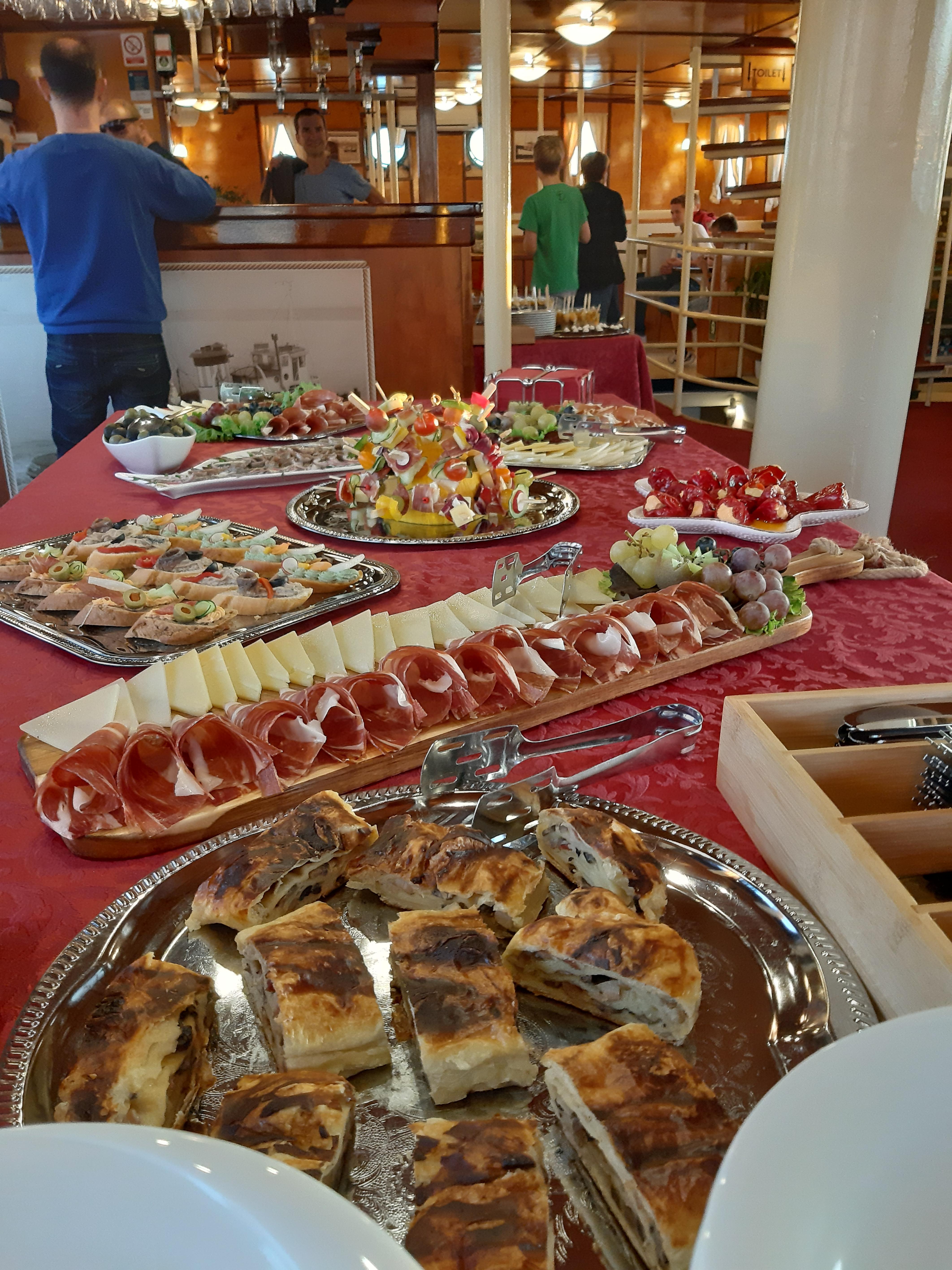 Appetizer spread with prosciutto, cheese, canapés and savory burek pastry slices