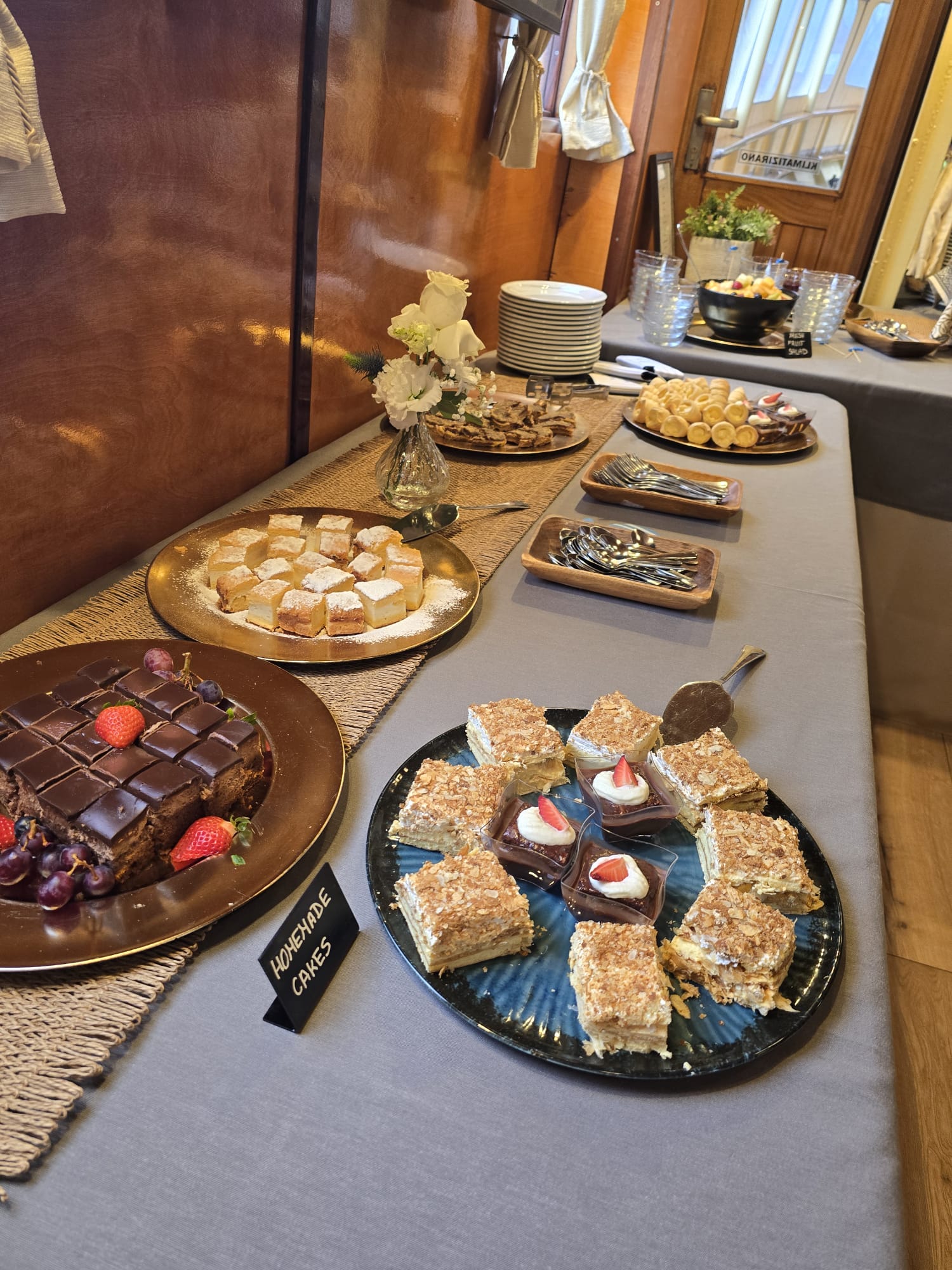 Dessert table with chocolate cake, cream slices and homemade cakes aboard Polaris