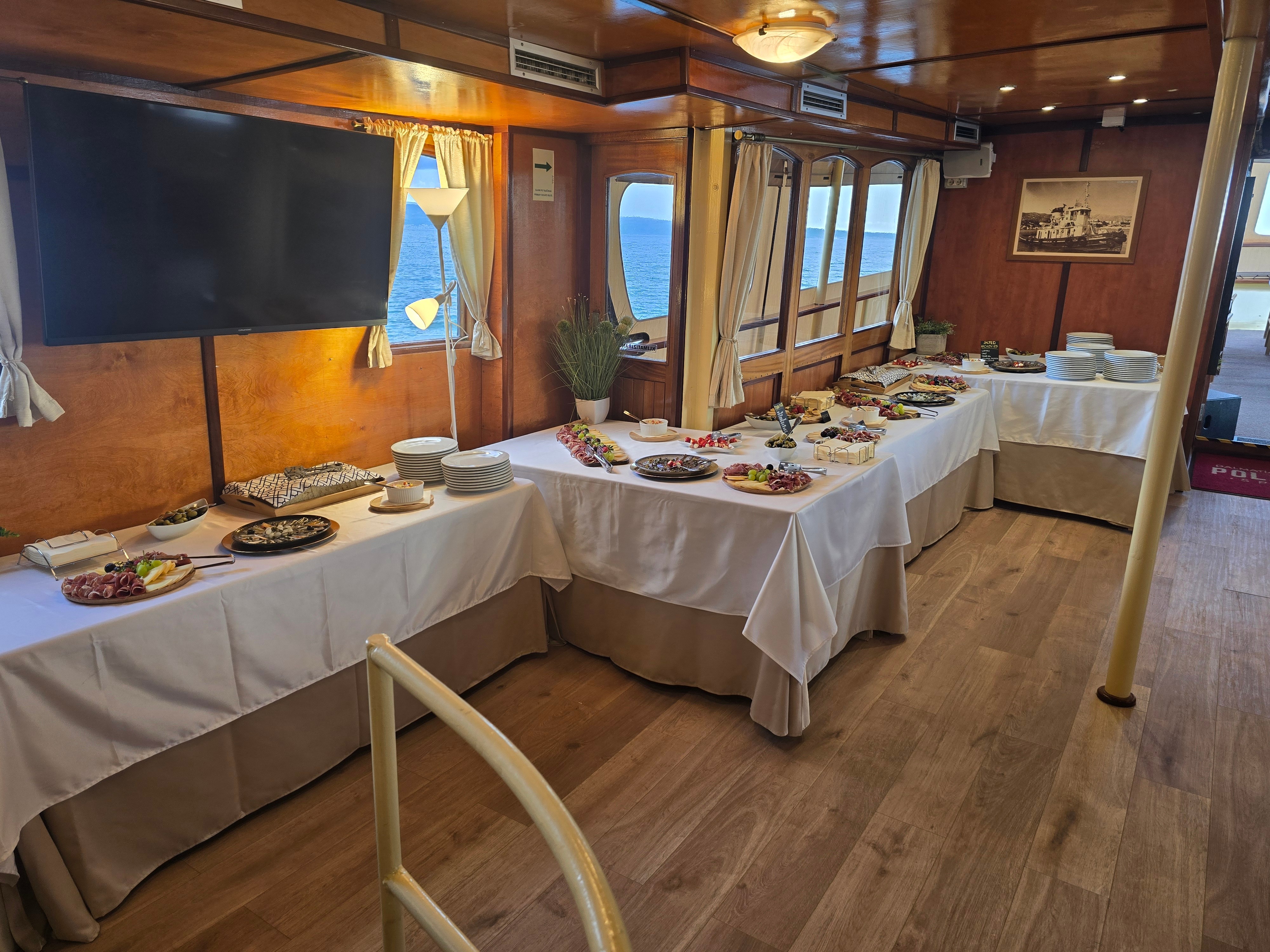 Long buffet tables of charcuterie and cheese in the Polaris dining lounge with sea views