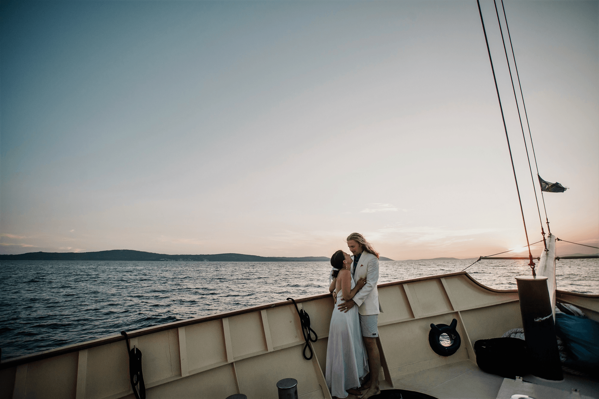 Frisch Vermählte umarmen sich bei Sonnenuntergang an Deck der Polaris auf der Adria