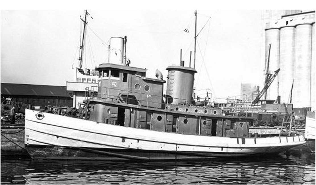 The future Polaris during fitting-out as DPC 95, moored at a dockyard with grain silos and a crane behind her