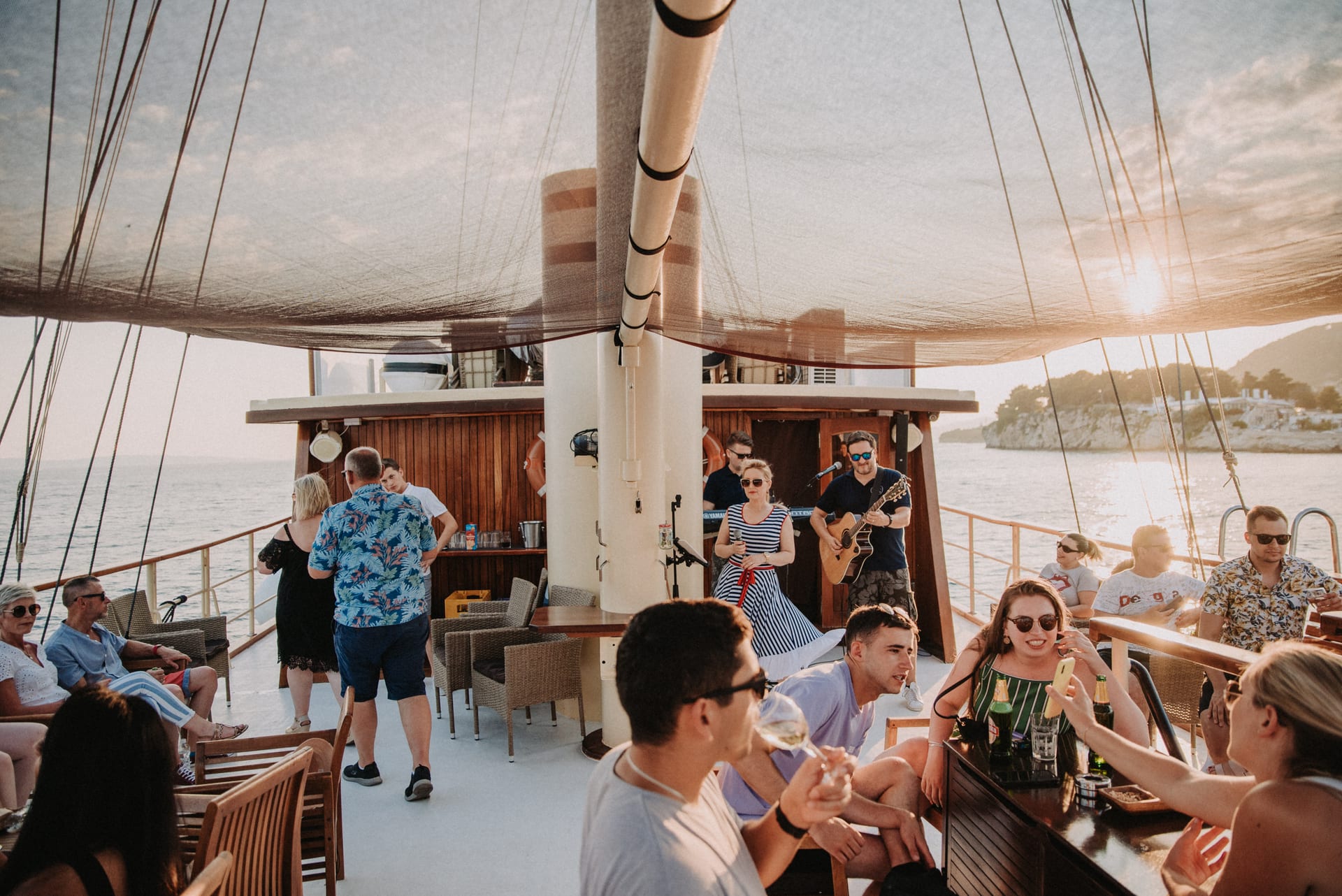 Live band performing on the open deck of Polaris at golden hour