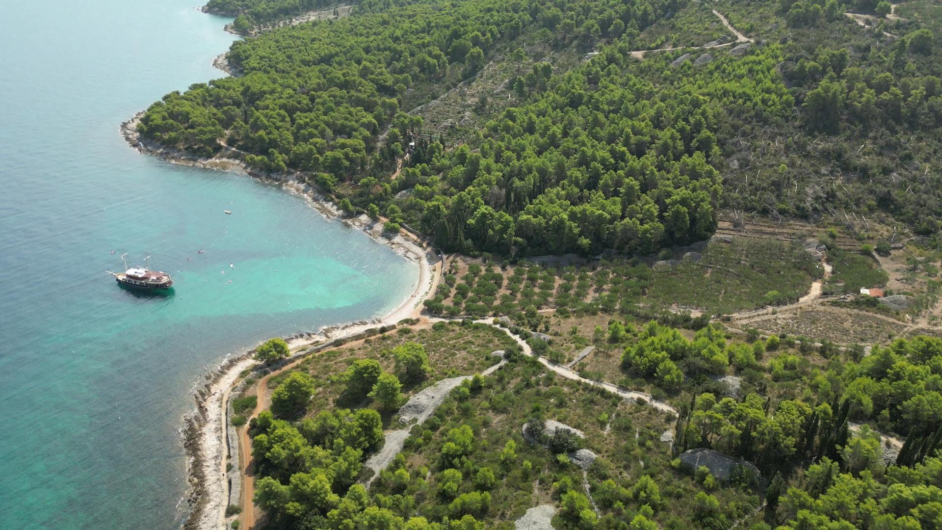 Drohnenaufnahme der Küste von Brač mit der Polaris vor Anker in einer Bucht