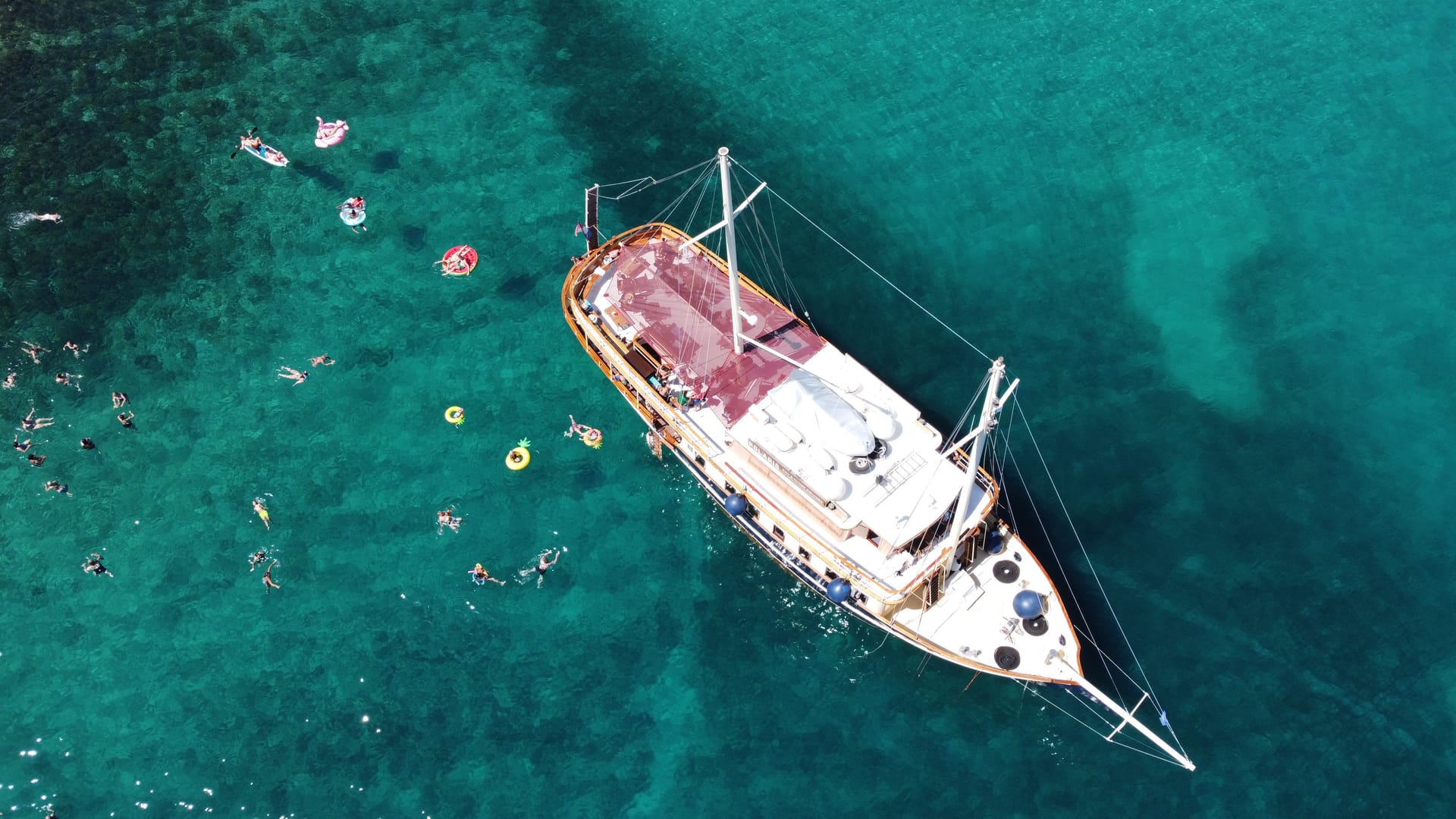 Top-down aerial of Polaris surrounded by swimmers and floats