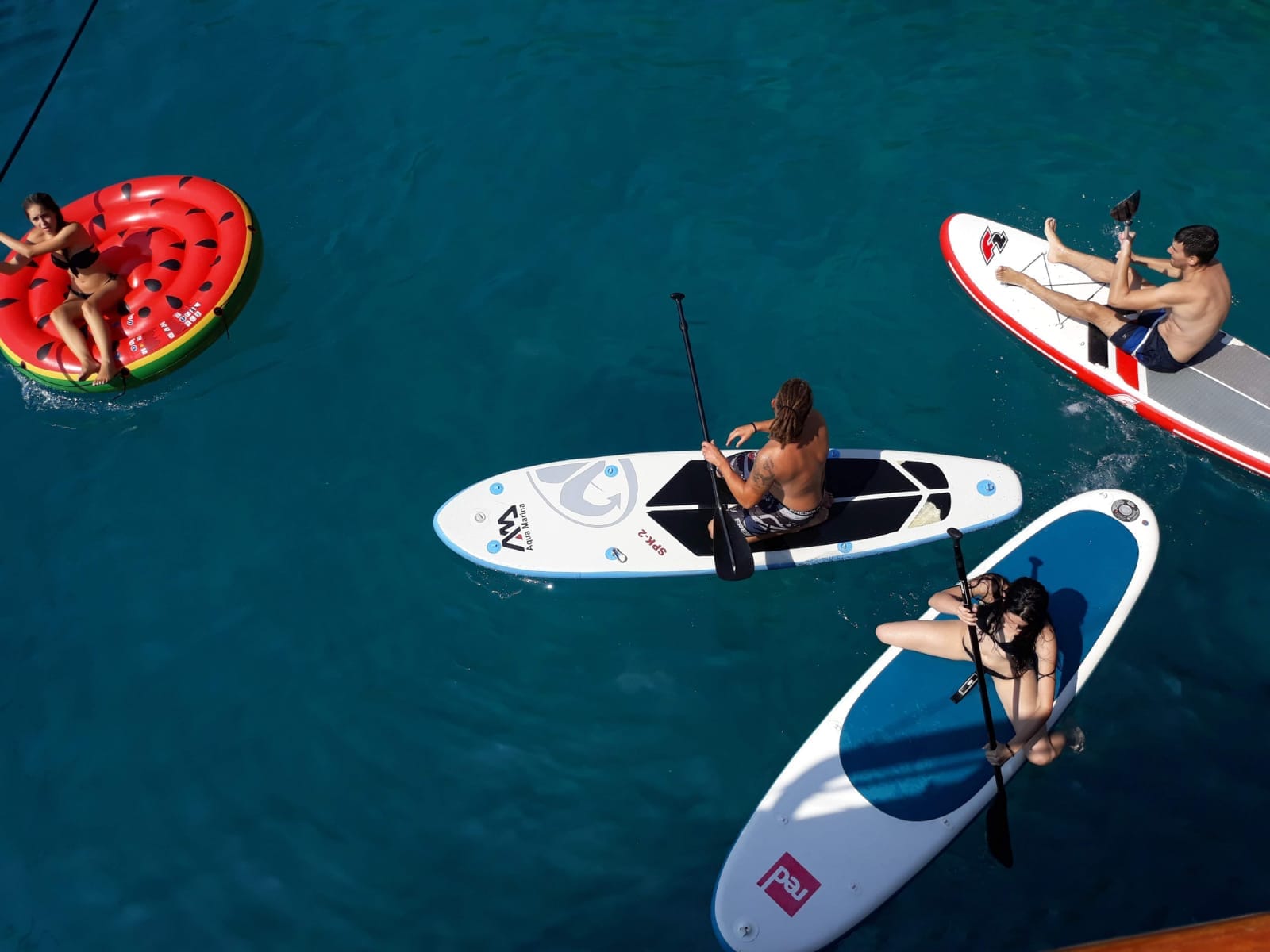 Stand-up paddle boarding and floats in crystal-clear water