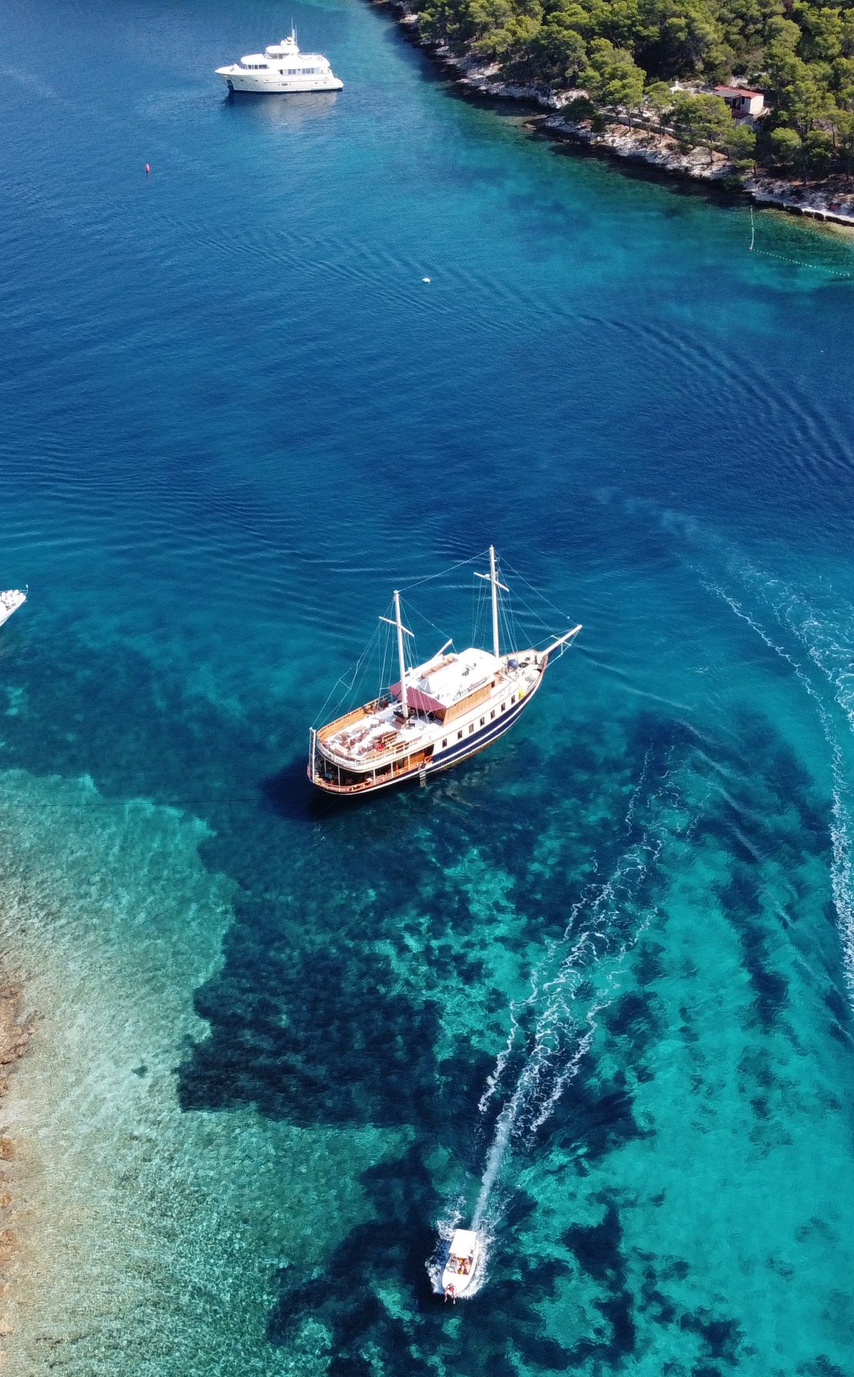 Aerial view of the yacht Polaris anchored among boats in a turquoise Adriatic bay near Split